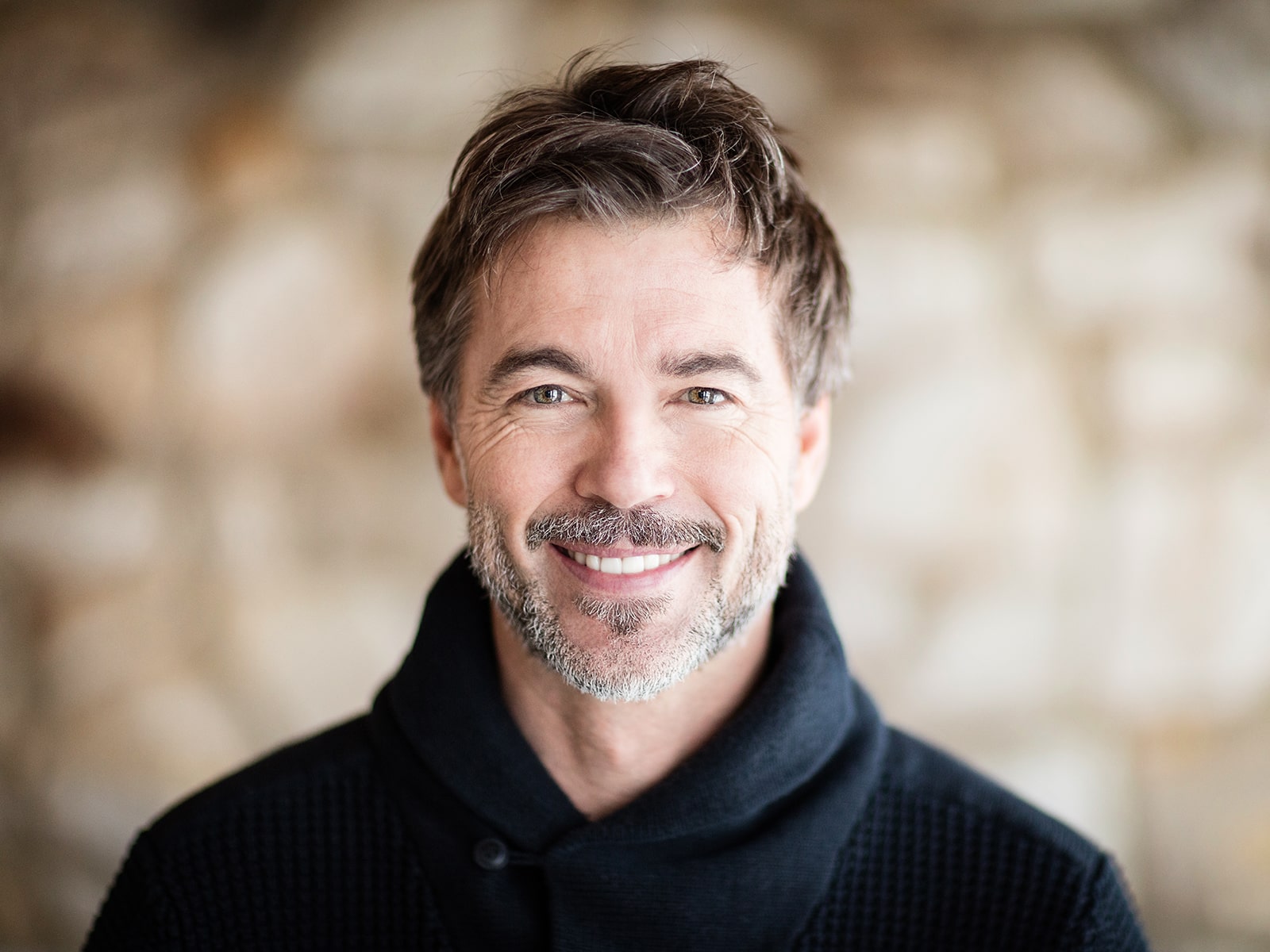 Man smiling wearing sweater-min Man smiling wearing sweater