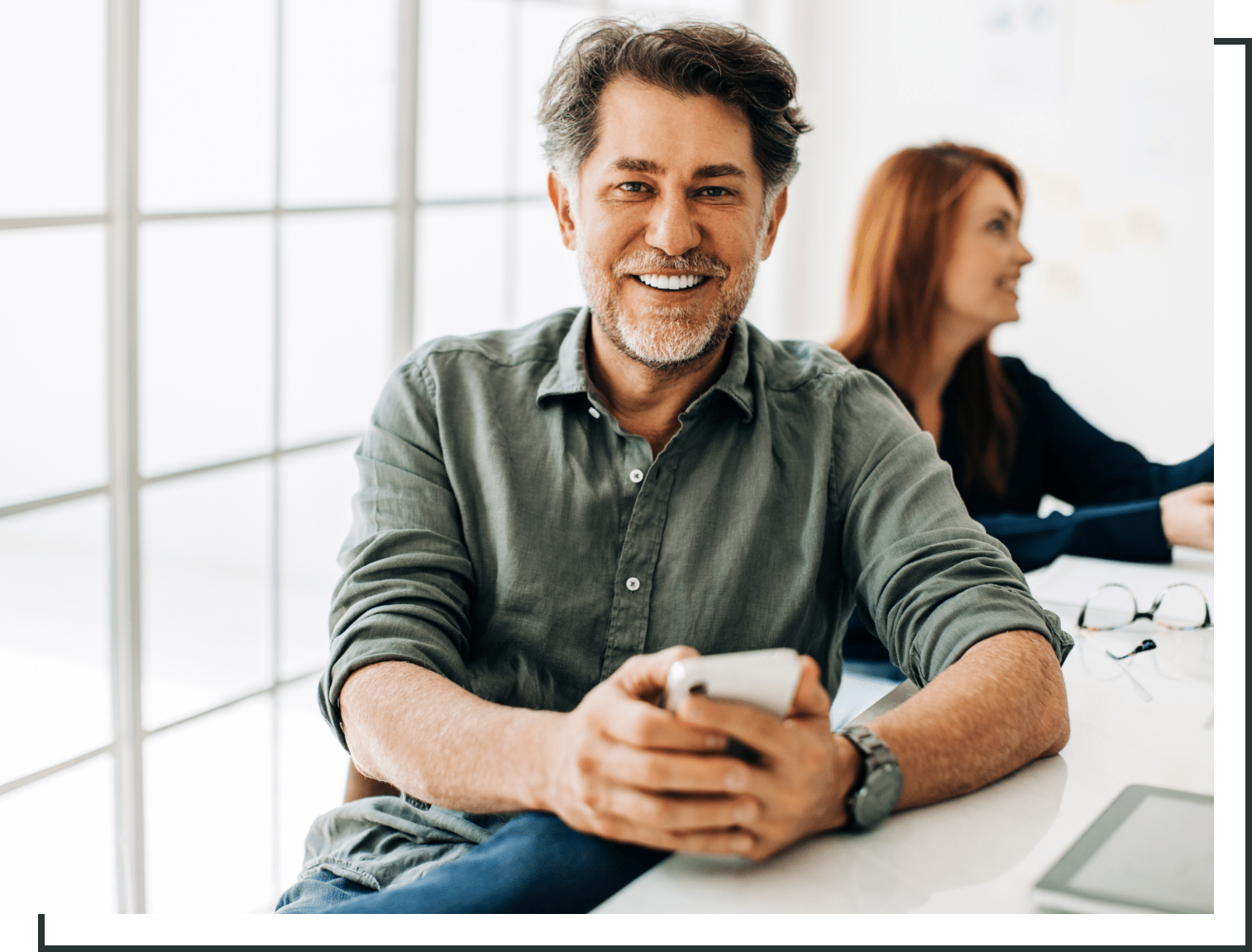 adult man smiling while sitting at a desk