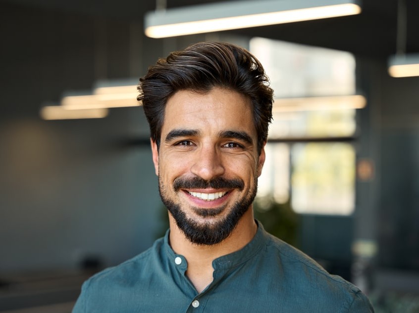 dark haired man in blue button up smiling