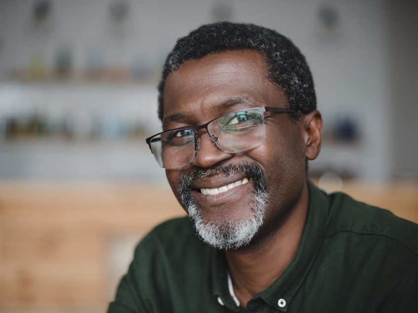 middle-aged man wearing glasses smiling with teeth